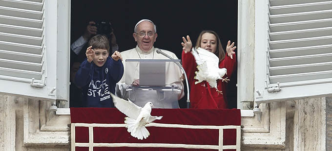 Pope Francis watches as children release doves from window of studio overlooking St. Peter's Square