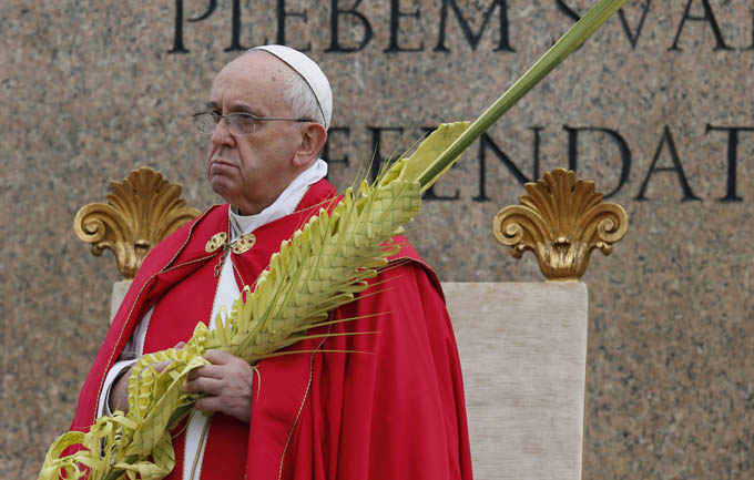 Pope Francis holds palms at the start of Palm Sunday Mass in St. Peter's Square at the Vatican April 13. (CNS photo/Paul Haring)