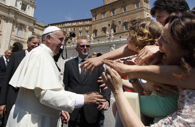 Pope Francis greets the crowd during his general audience in St. Peter's Square at the Vatican. (CNS photo/Paul Haring)