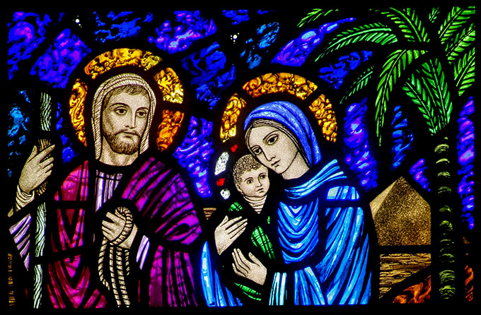 A detail of a stained-glass window from St. Edward's Church in Seattle shows Jesus, Mary and Joseph on their flight into Egypt. The feast of the Nativity of Christ, a holy day of obligation, is celebrated Dec. 25. The feast of the Holy Family is marked Dec. 29. (CNS/Crosiers) 