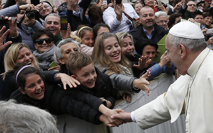 Pope Francis greets people while leaving the general audience in St. Peter's Square at the Vatican Nov. 26. (CNS photo/Paul Haring) 