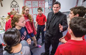 Father Alfonse Nazzaro interacts with eighth-grade students at All Saints Catholic School on Dec. 18. (RON HEFLIN/Special Contributor)