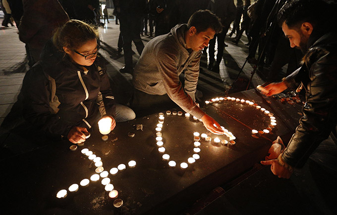 People light candles in the shape of a cross and heart in Republique square in Paris Nov. 14 in memory of victims of terrorist attacks. Coordinated attacks the previous evening claimed the lives of 129 people. The Islamic State claimed responsibility. (CNS photo/Paul Haring)