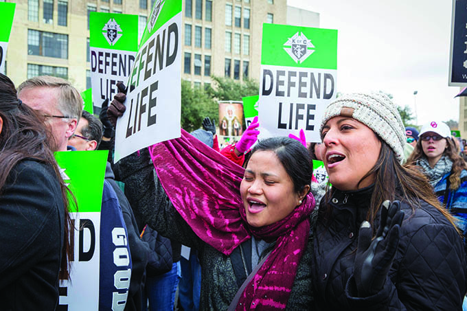 Ellanie Berba, left, and Jasmin Penny, both parishioners at St. Michael the Archangel Catholic Church in McKinney, sing at a pro-life rally outside the Earle Cabell Federal Building. (RON HEFLIN/Special Contributor)