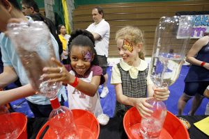 Lizzie Osborne, 9, and Savanah Wolfson, 9, shake bottles of water to create a tornado, at a JPII booth showing how tornadoes work, during STEM Day at St. Mark the Evangelist Catholic School, on Friday, April 8, 2016 in Plano. (Ben Torres/Special Contributor)