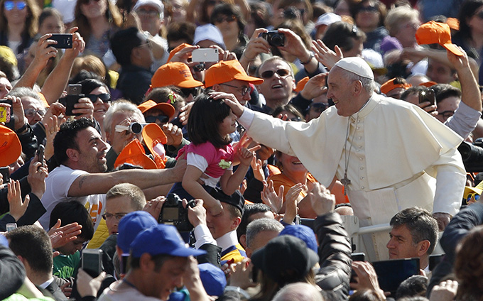 Pope Francis blesses a child during a special audience for military members and their families in St. Peter's Square at the Vatican April 30. (CNS photo/Paul Haring) 