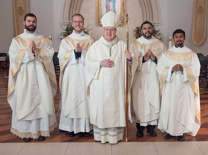 Bishop Kevin J. Farrell, center, with new priests for the Diocese of Dallas, from left, Father Paul Stephen Bechter, Father Emmett V. Hall, Father Ignacio Olvera Ortiz and Father Daniel Rendón following their ordination Mass at the Cathedral Shrine of the Virgin of Guadalupe on May 21. (JENNA TETER/The Texas Catholic)