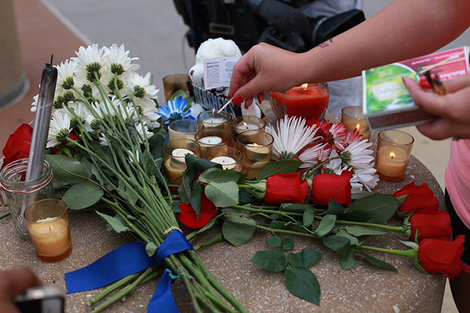 A woman lights a candle at a makeshift memorial outside of the Dallas Police Department headquarters in Dallas July 8. The prior evening gunmen shot and killed five police officers and wounded seven during a peaceful protest in downtown Dallas. The protest was in reaction after two black men were fatally shot by police officers in Baton Rouge, La., and Minneapolis. (Rebecca Kirstin Patton/Special Contributor)