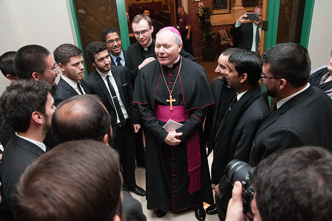 Bishop Edward J. Burns visits with seminarians prior to Solemn Vespers on Feb. 8. (JENNA TETER/The Texas Catholic)